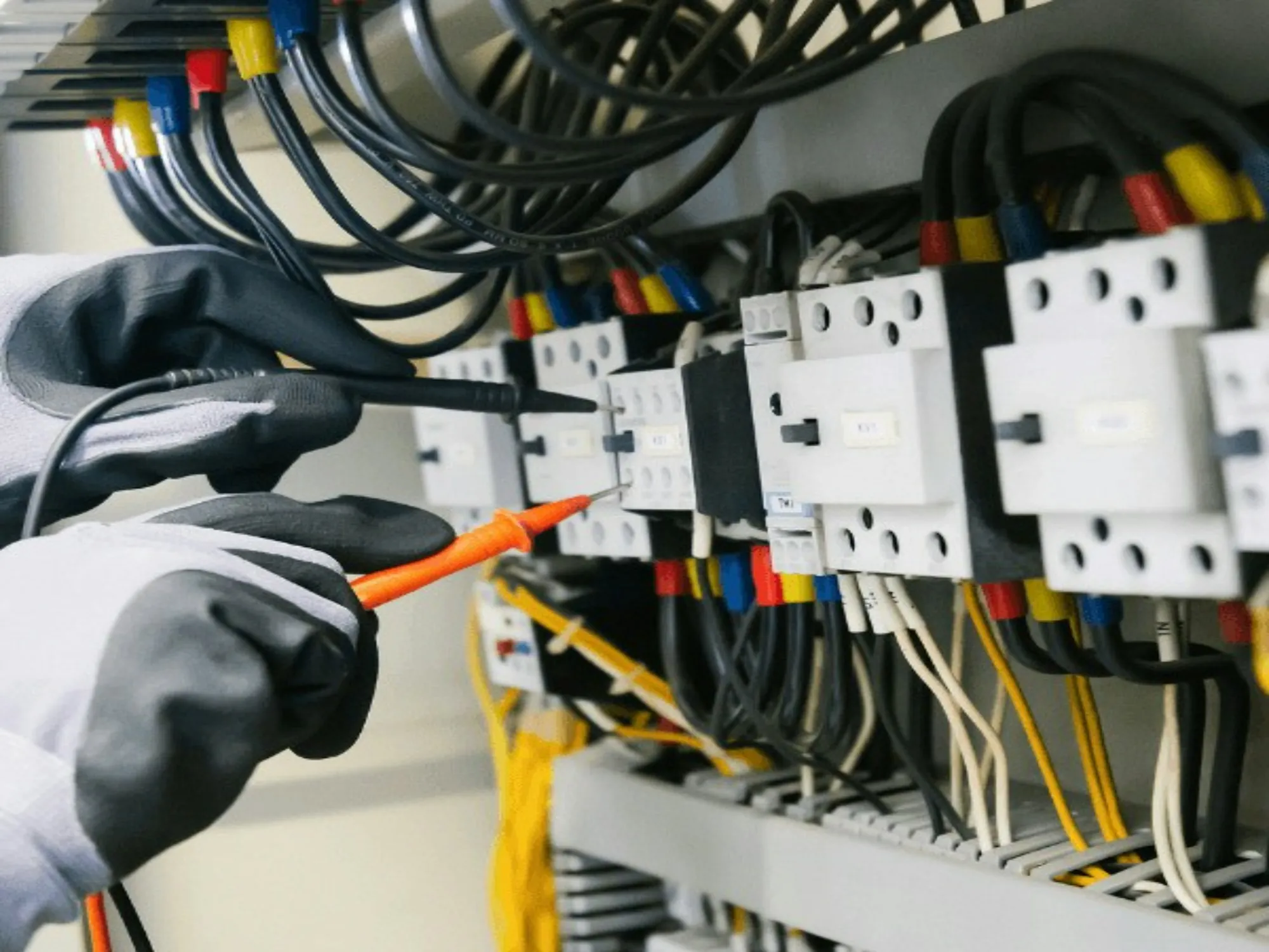 Electrician working on an electrical panel with a screwdriver